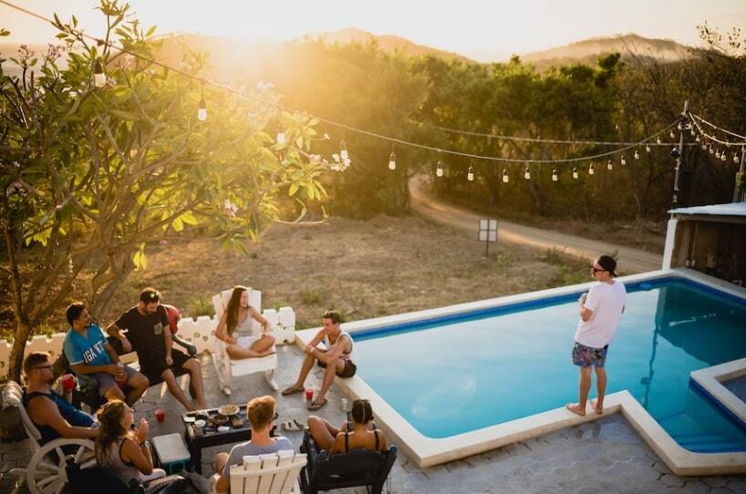 A-garden-with-a-swimming-pool-and-people-sitting-on-garden-chairs-around-a-table