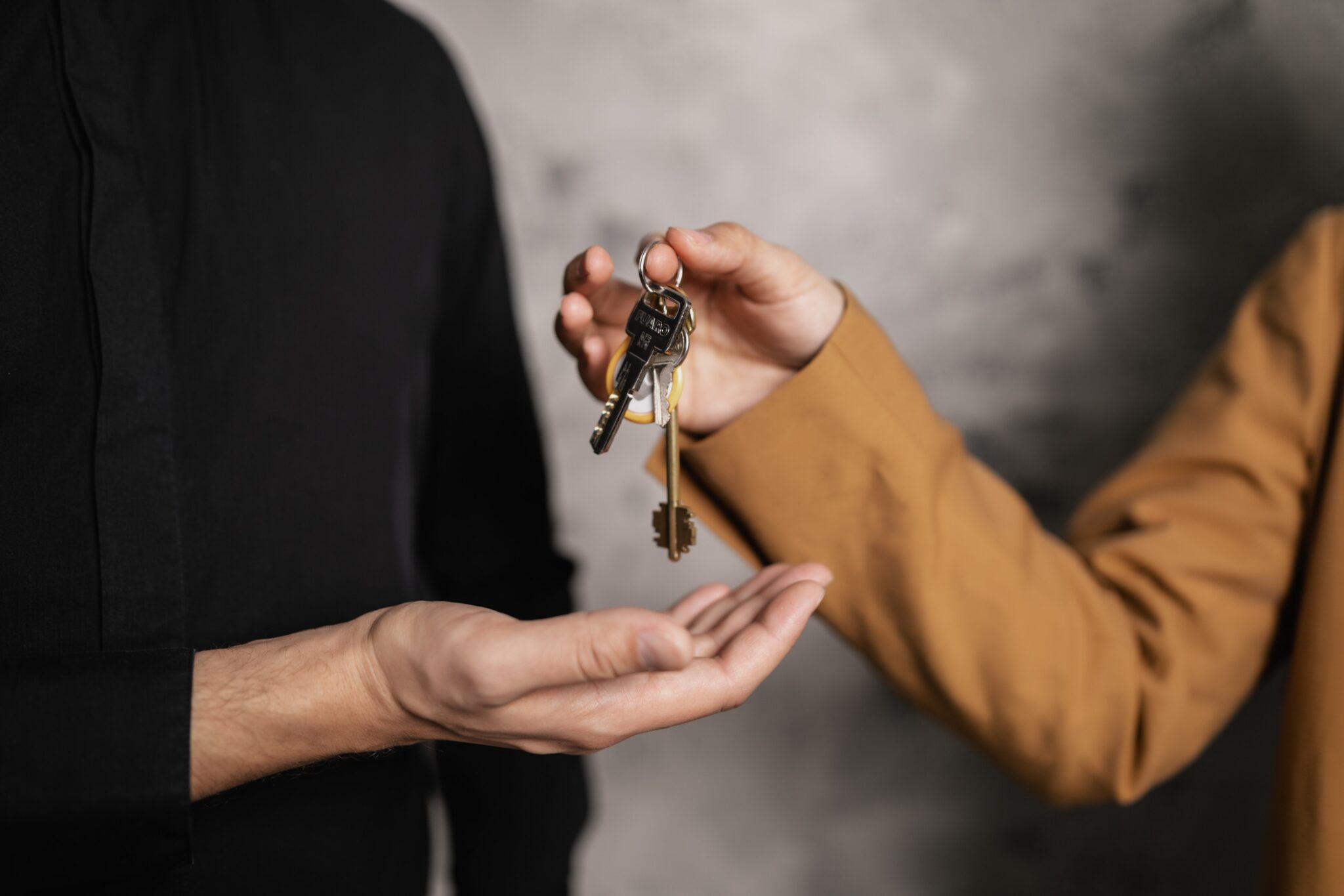 01-A-Person-Giving-a-Bundle-of-Keys-to-another-Person-2048x1365