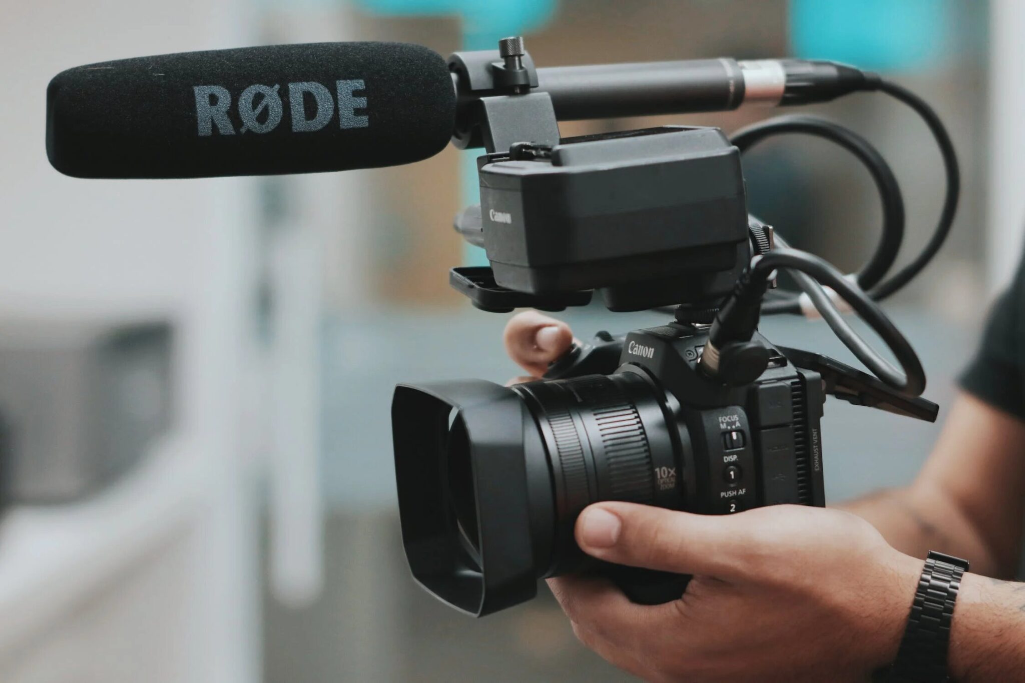 Person-holding-a-professional-camera-with-a-microphone-attached-2048x1365