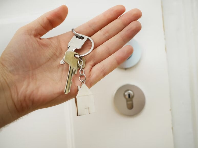 person-holding-the-keys-to-newly-bought-estate-property