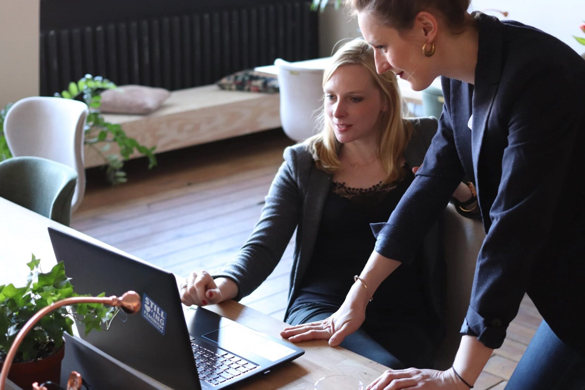 Mentor-explaining-something-on-a-computer-to-her-mentee-1900x1267