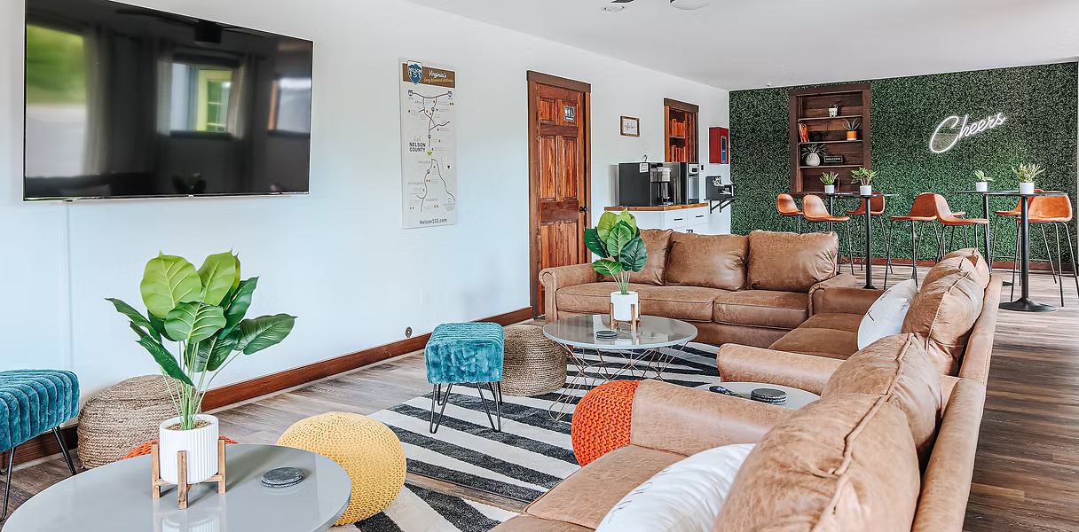 An inviting common space that includes leather sofas, a coffee table, and a striped rug.