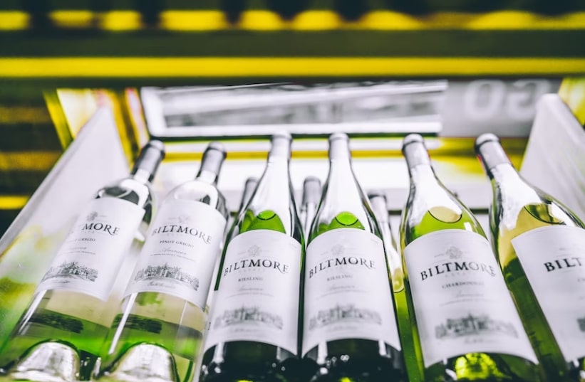 Wine bottles lying in rows inside a wine fridge 