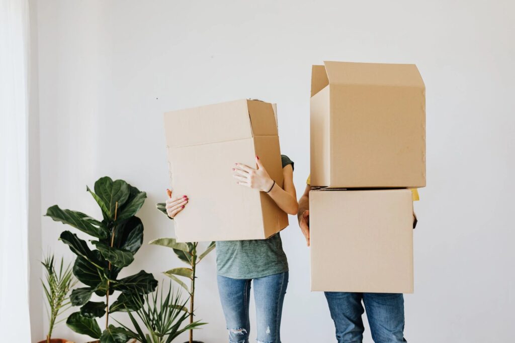 two people holding cardboard boxes on moving day